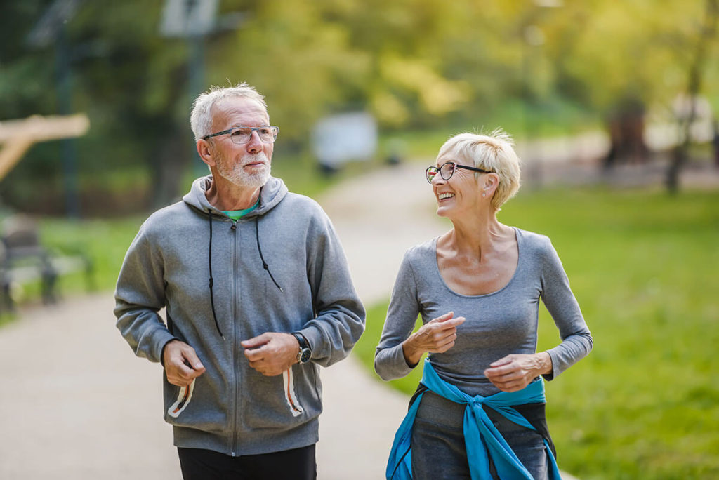 Smiling senior couple jogging in the park